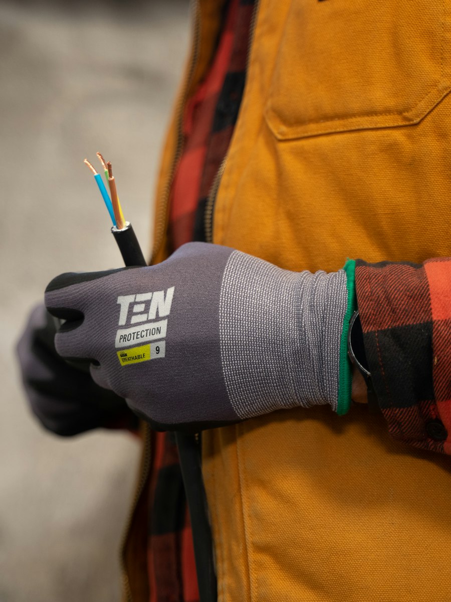 A gloved hand holding a stripped electrical cable