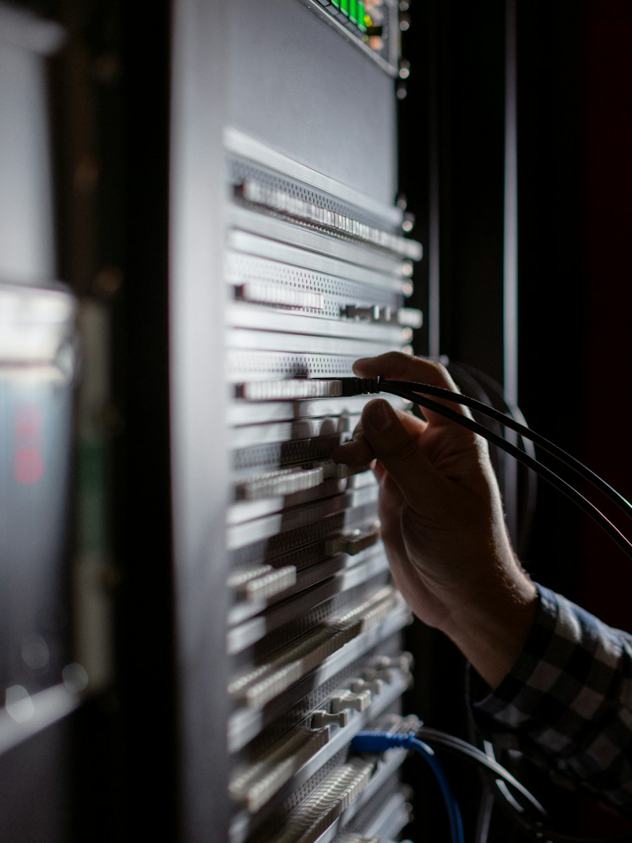 An electrician working on a terminal strip inside a control panel