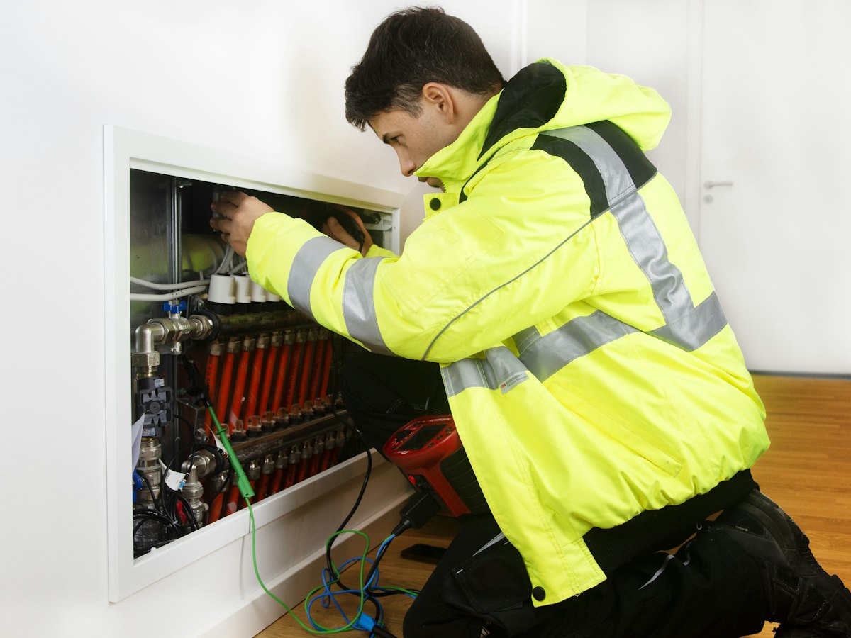 An electrician testing a wall mounted distribution board
